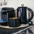 Sleek black coffee maker and kettle on a modern kitchen countertop, ideal for brewing.