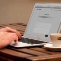 https://www.pexels.com/it-it/foto/umano-utilizzando-laptop-accanto-a-tazza-da-te-sul-tavolo-di-legno-221043/