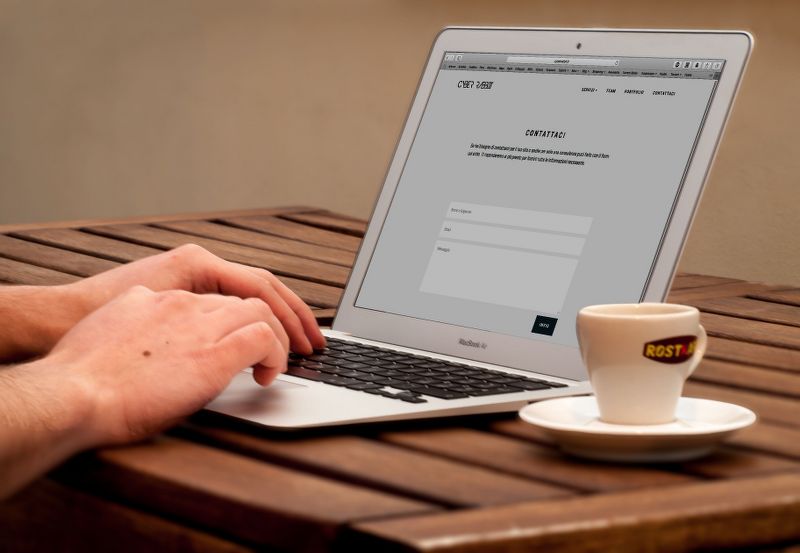 https://www.pexels.com/it-it/foto/umano-utilizzando-laptop-accanto-a-tazza-da-te-sul-tavolo-di-legno-221043/